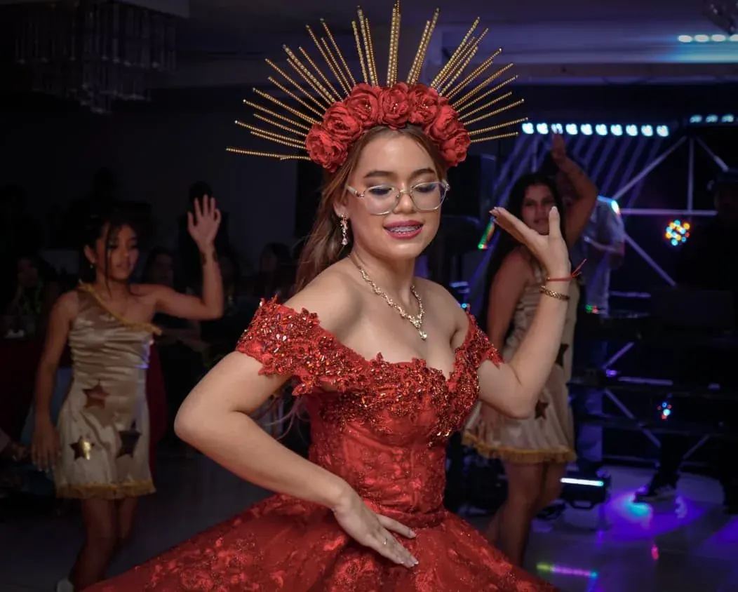 Retrato de quinceañera con vestido rojo junto a un invitado